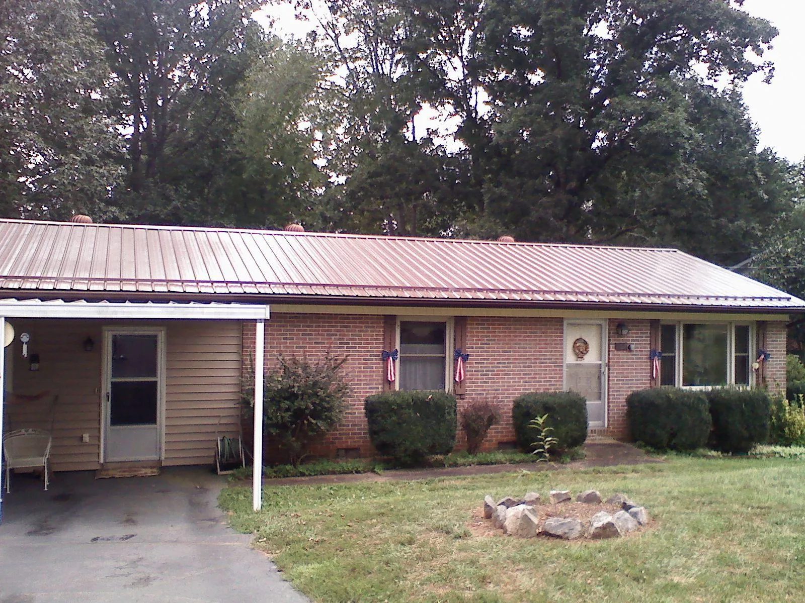 Bronze metal roof and carport on a brick ranch home — Roof Repair work by our crew in Meacham